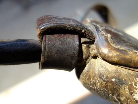 Lederöse für Hornriemen festgenäht in Lederüberzug des Eisenbügels