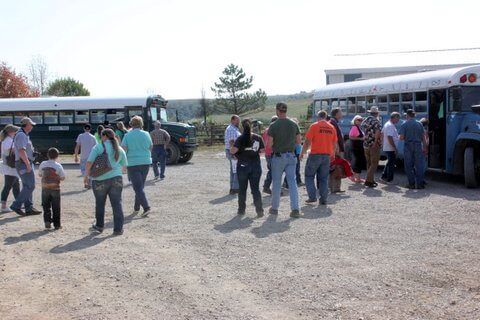 Guests load on the ranch buses for pasture tours and moving to the measuring corrals.