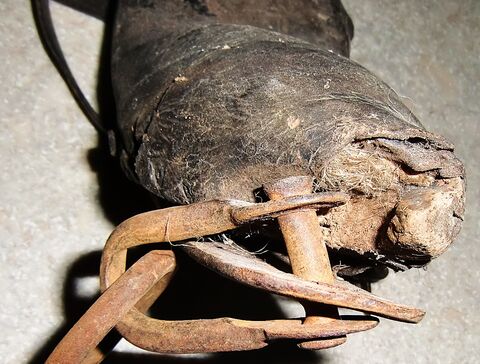 Schäkel mit Niete die ursprünglich durch Eisen und Holz ging und vom Lederansatz umschlossen war
