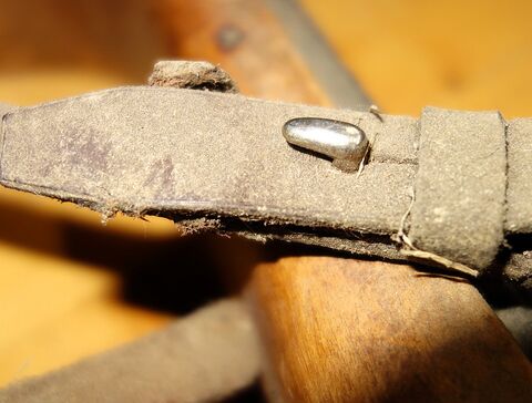 Verschluß des schmalen, rundgenähten Riemens am Knebeljoch hinten