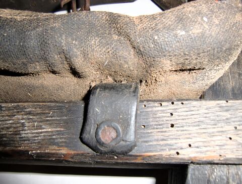 Lederriemen durchläuft das gesamte Polster von oben bis unten und ist am Holz festgenagelt